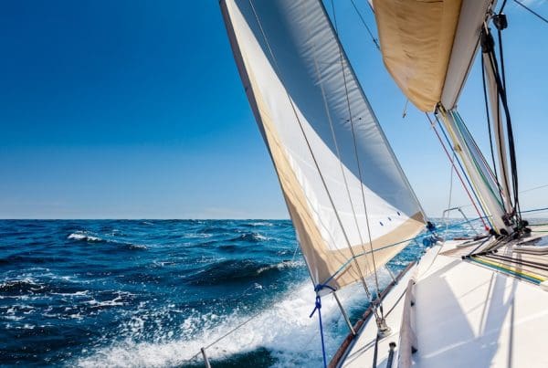 White sailing boat at open sea in sunshine